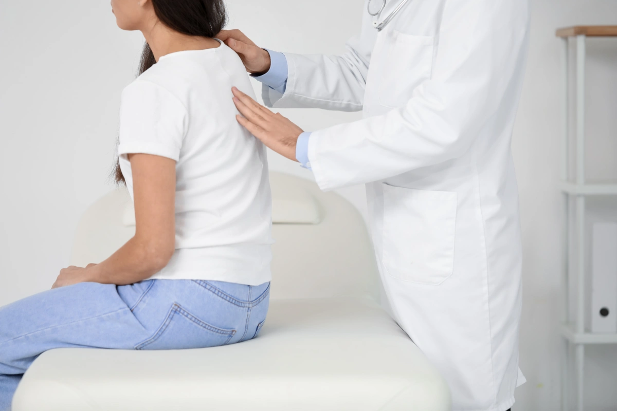 male-doctor-checking-posture-young-woman